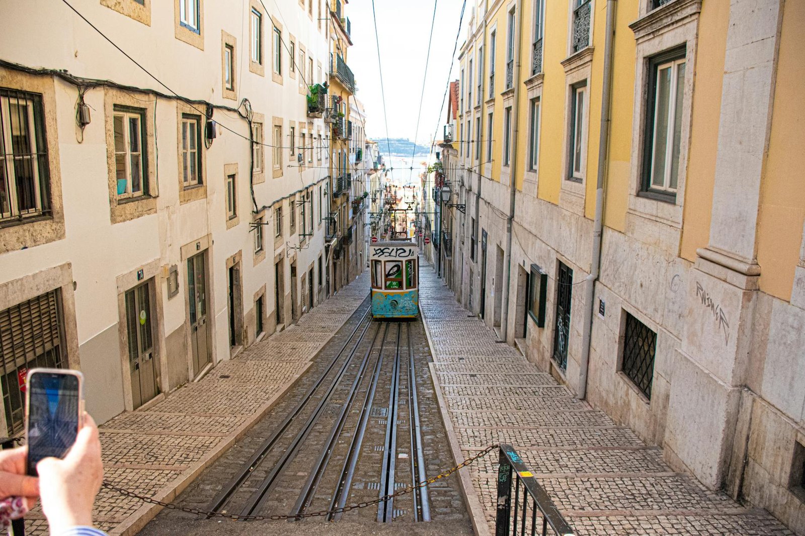 Colorful Lisbon tram on a steep, historic street. Shows daily life in Portugal.