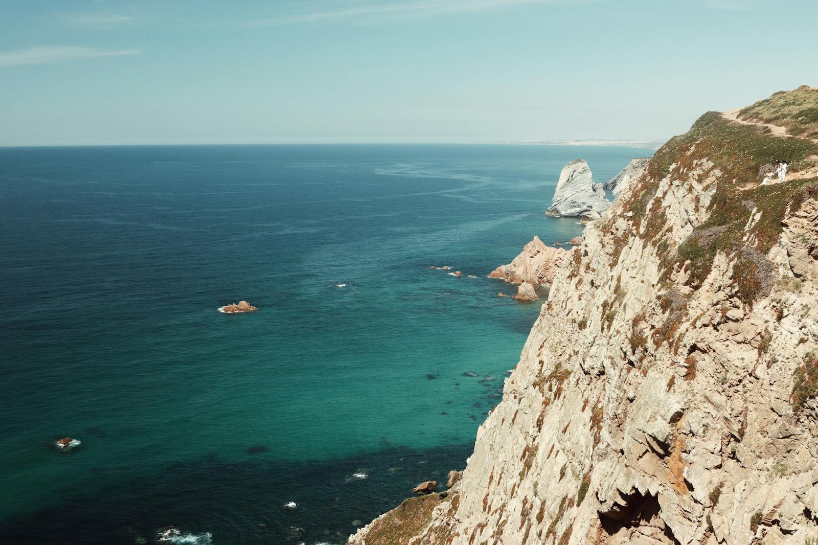 Breathtaking view of Cabo da Roca's cliffs meeting the blue Atlantic Ocean in Portugal.