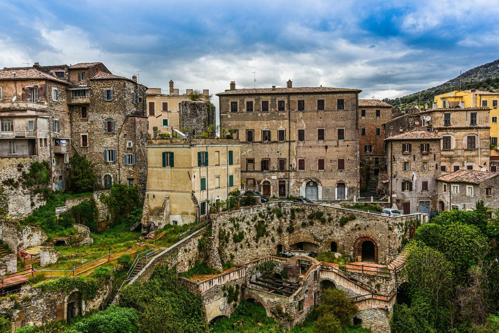 Charming historic buildings in Tivoli, Italy under a cloudy sky.